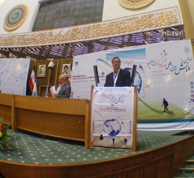 Juergen Steinmetz speaking at the Islamic Hall of the People in Teheran in 2008. Sitting next to him is Louis D’Amore founder and president of IIPT.